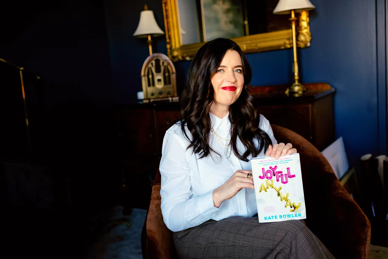 Kate Bowler holding a copy of Joyful, Anyway